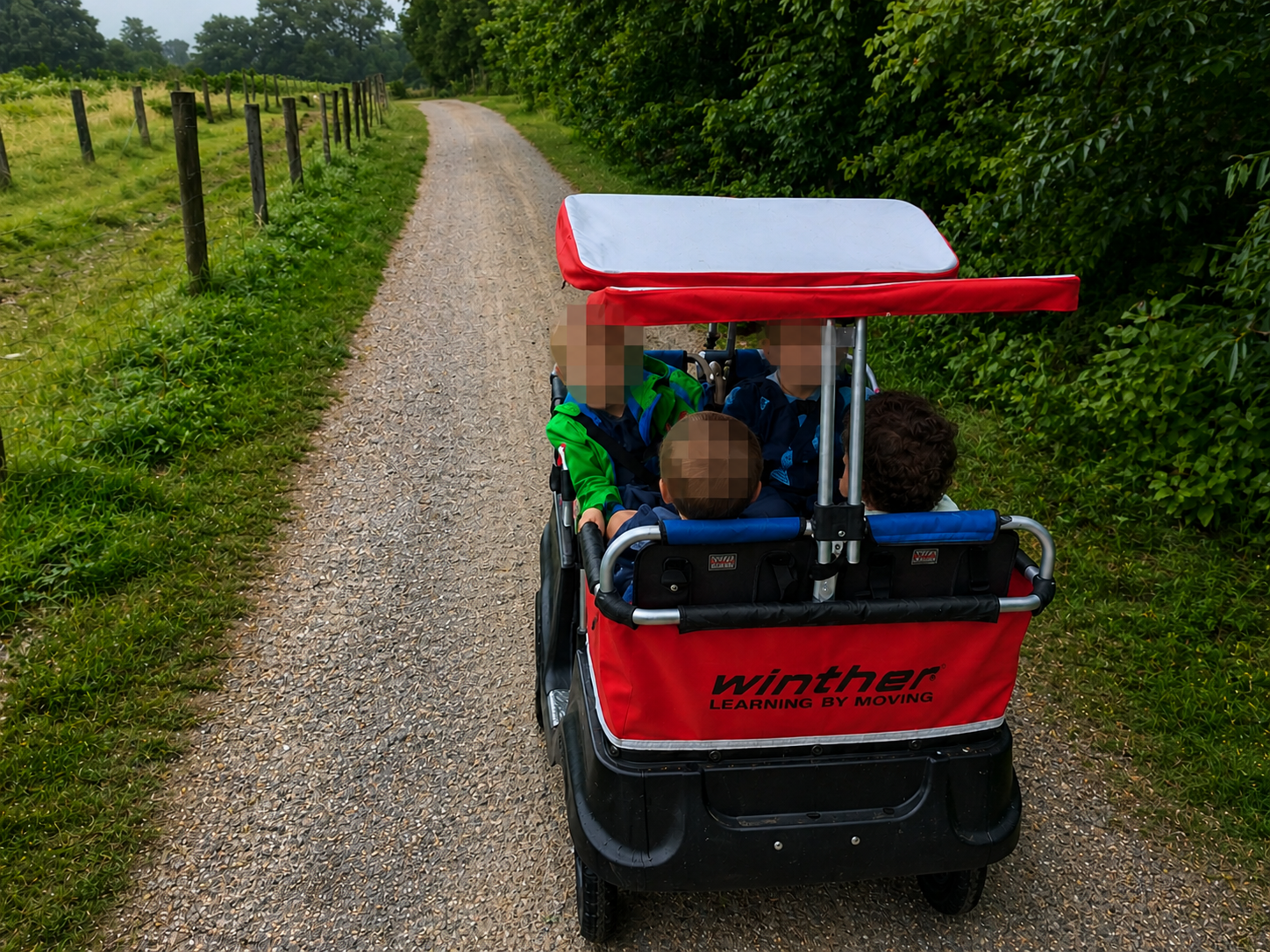 Kinder sitzen im Turtlebus auf einem Hof mit einer bunten Einkaufstasche