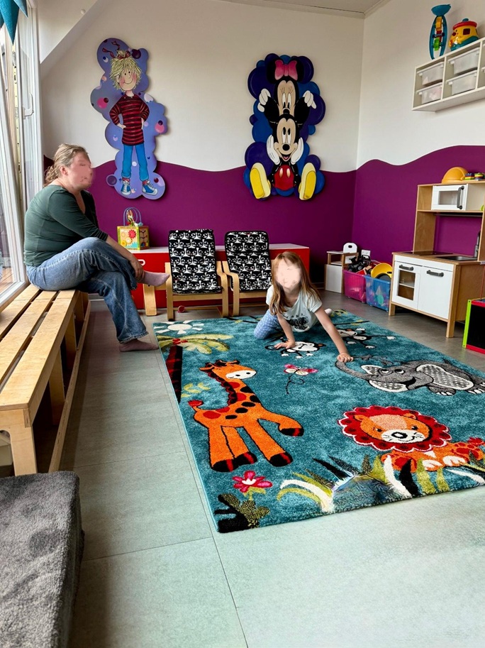Spielbereich mit buntem Teppich und kindgerechter Einrichtung
